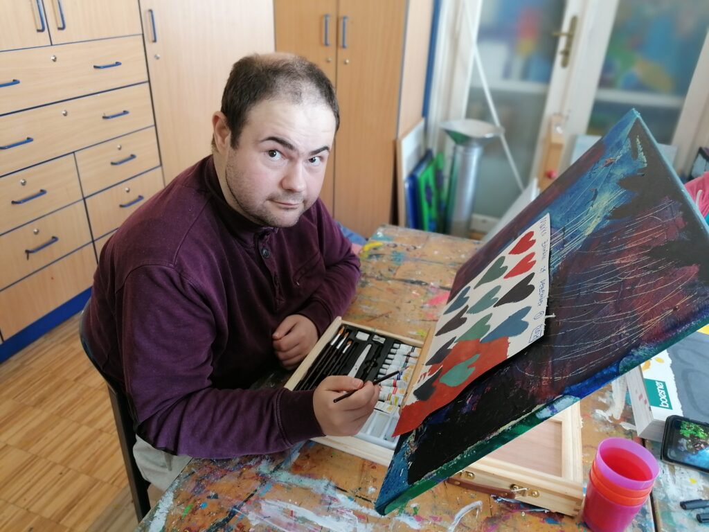 Ein Klient beim malen von Herzen mit Acrylfarben.