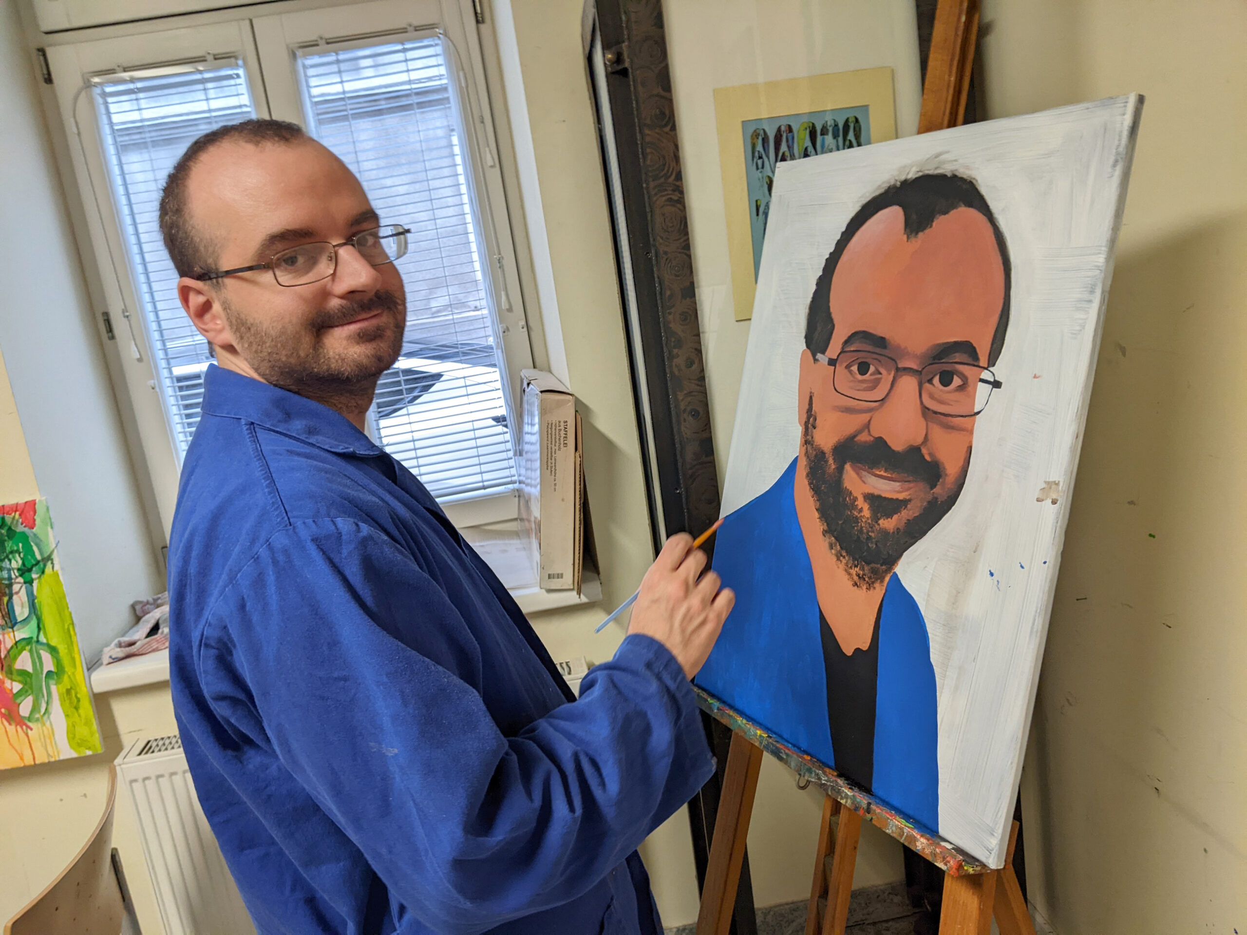 Klient der Künstlergruppe malt ein Selbstportrait.