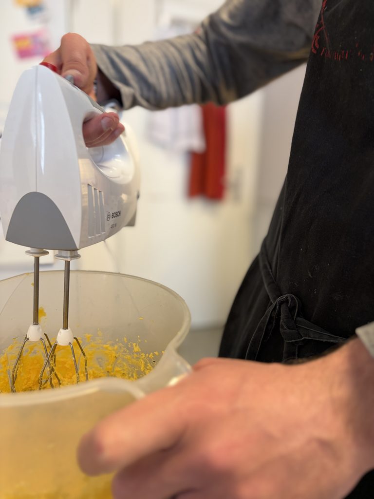 Eine Klientin der Haushaltsgruppe mixt einen Teig.